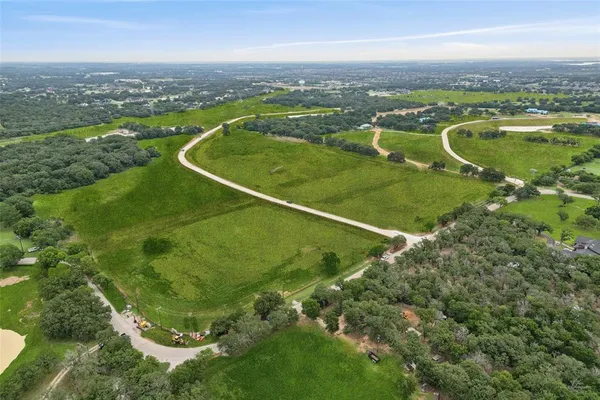 an aerial view of residential houses with outdoor space and trees