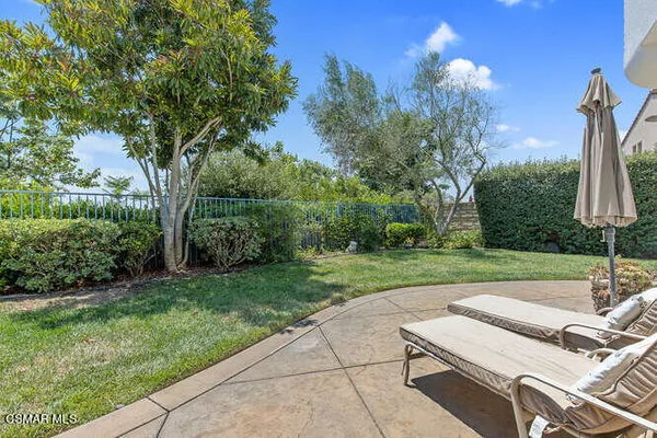 a view of a patio with a table chairs and a floor to ceiling window