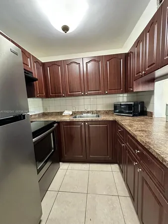 a kitchen with stainless steel appliances granite countertop a stove a sink dishwasher and a microwave oven with cabinets