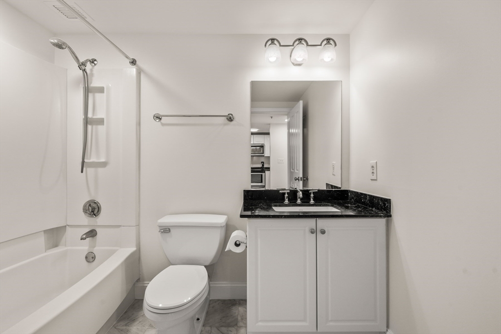 8 Museum Way, Unit 1006 Cambridge, MA 02141 - Photo 17 of 21 a bathroom with a granite countertop sink a toilet and shower