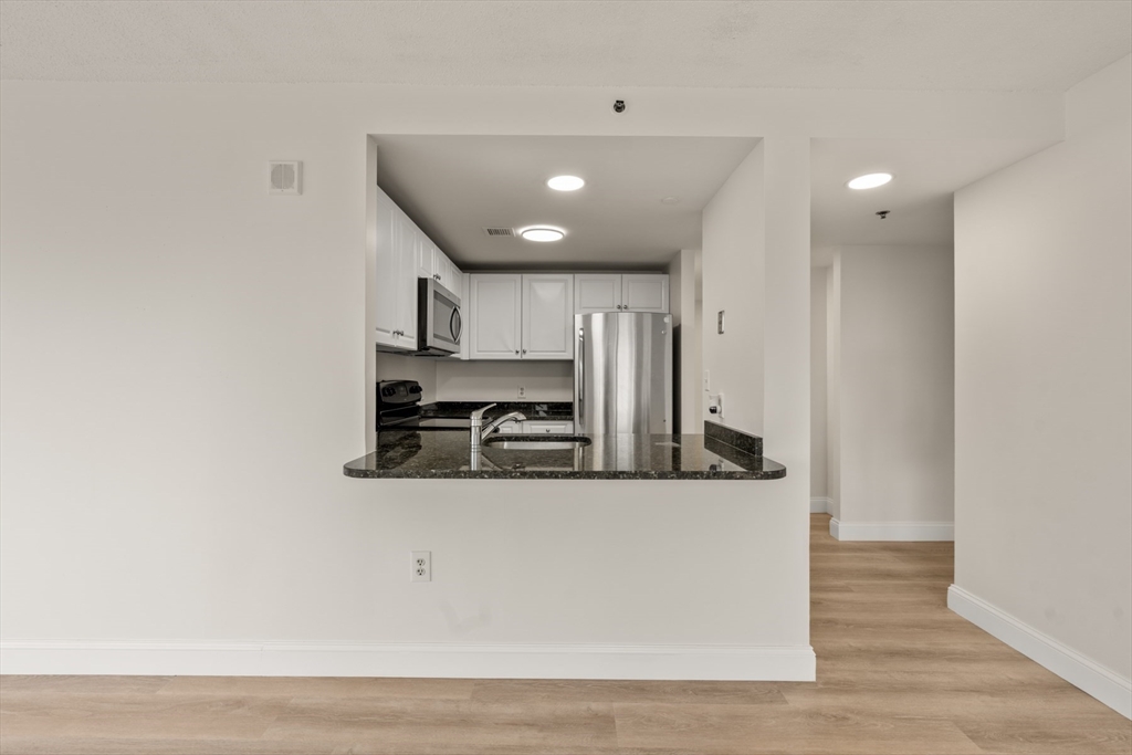 8 Museum Way, Unit 1006 Cambridge, MA 02141 - Photo 7 of 21 a view of a kitchen with stainless steel appliances granite countertop cabinets and wooden floor