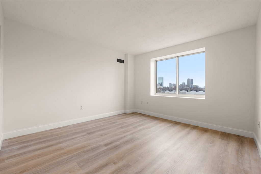 8 Museum Way, Unit 1006 Cambridge, MA 02141 - Photo 10 of 21 a view of an empty room with wooden floor and a window