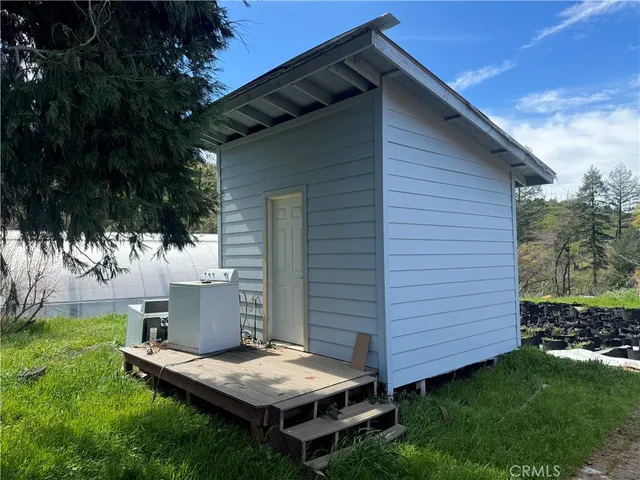 a view of backyard with barbeque grill and wooden fence
