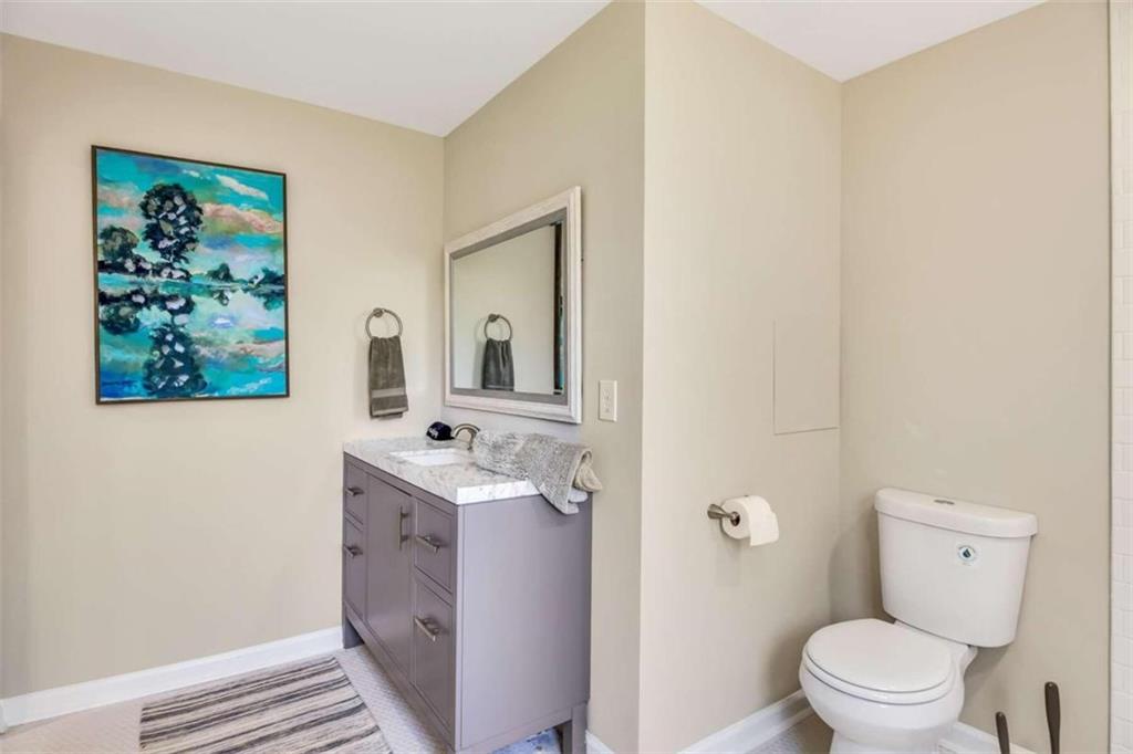 1386 Sandtown Road Southwest Marietta, GA 30008 - Photo 11 of 23 a bathroom with a toilet a sink and mirror
