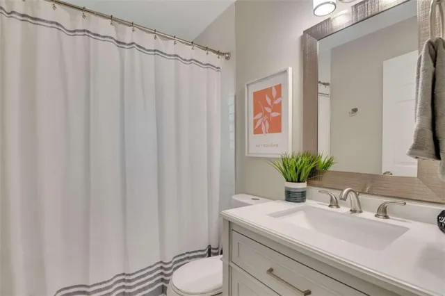 a bathroom with a sink a toilet and shower curtain