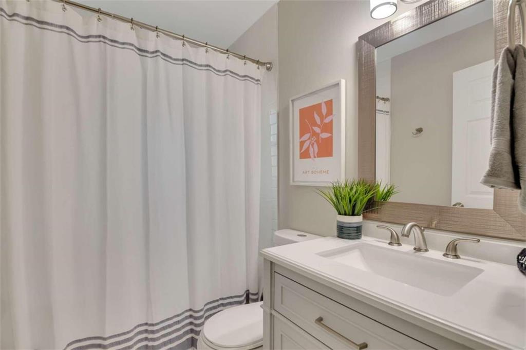 1386 Sandtown Road Southwest Marietta, GA 30008 - Photo 15 of 23 a bathroom with a sink a toilet and shower curtain