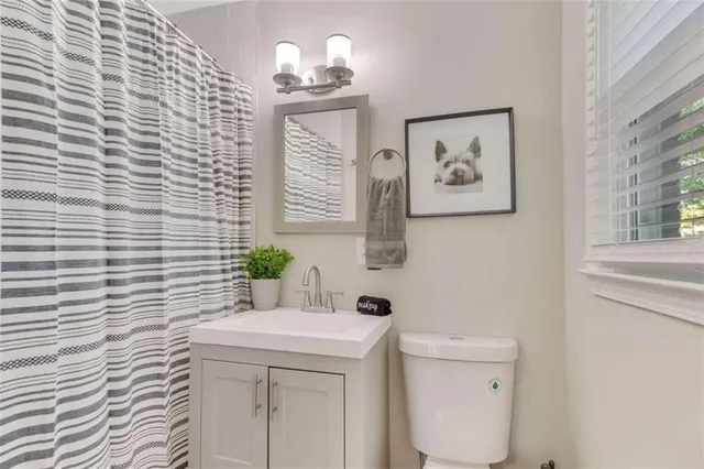 a bathroom with a sink a toilet and a window