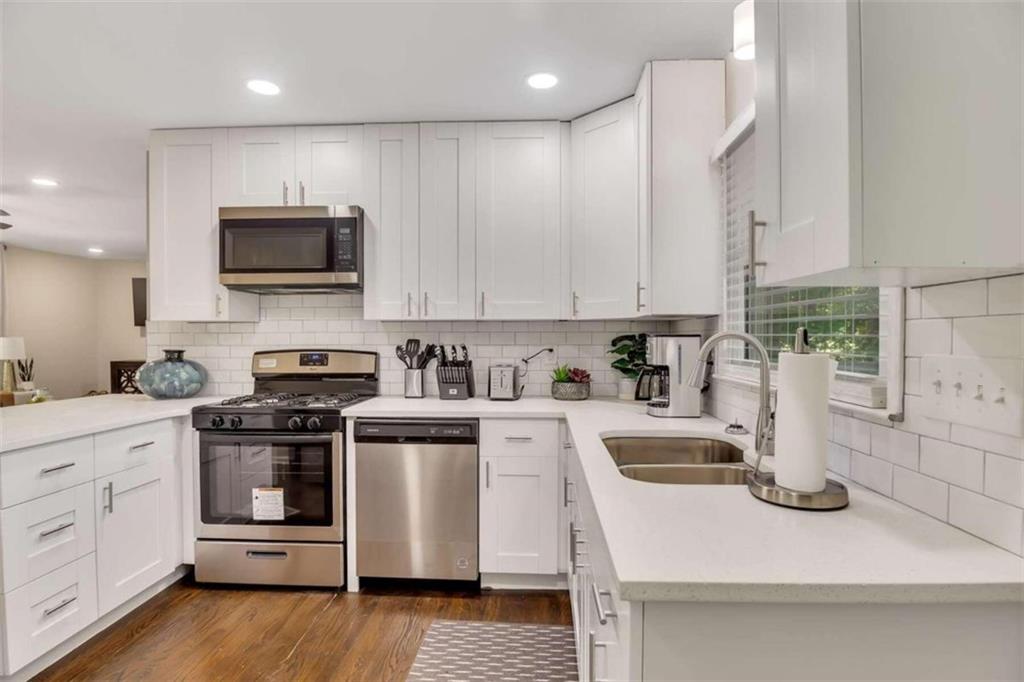 1386 Sandtown Road Southwest Marietta, GA 30008 - Photo 3 of 23 a kitchen with a sink a stove and cabinets