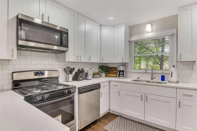 a kitchen with cabinets stainless steel appliances and window