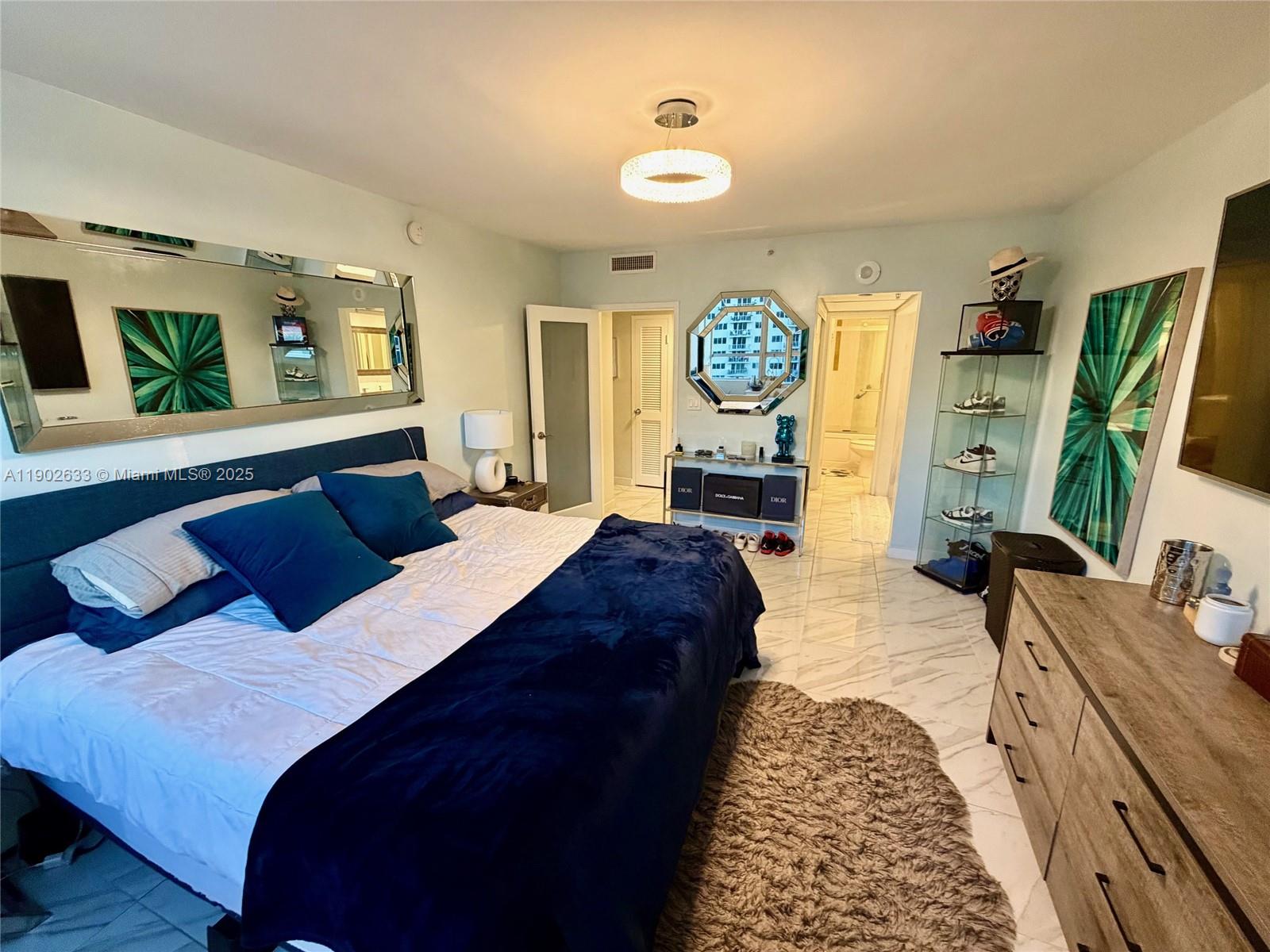 1500 Bay Road, Unit 846S Miami Beach, FL 33139 - Photo 11 of 40 a bedroom with a bed a mirror on dresser and a window