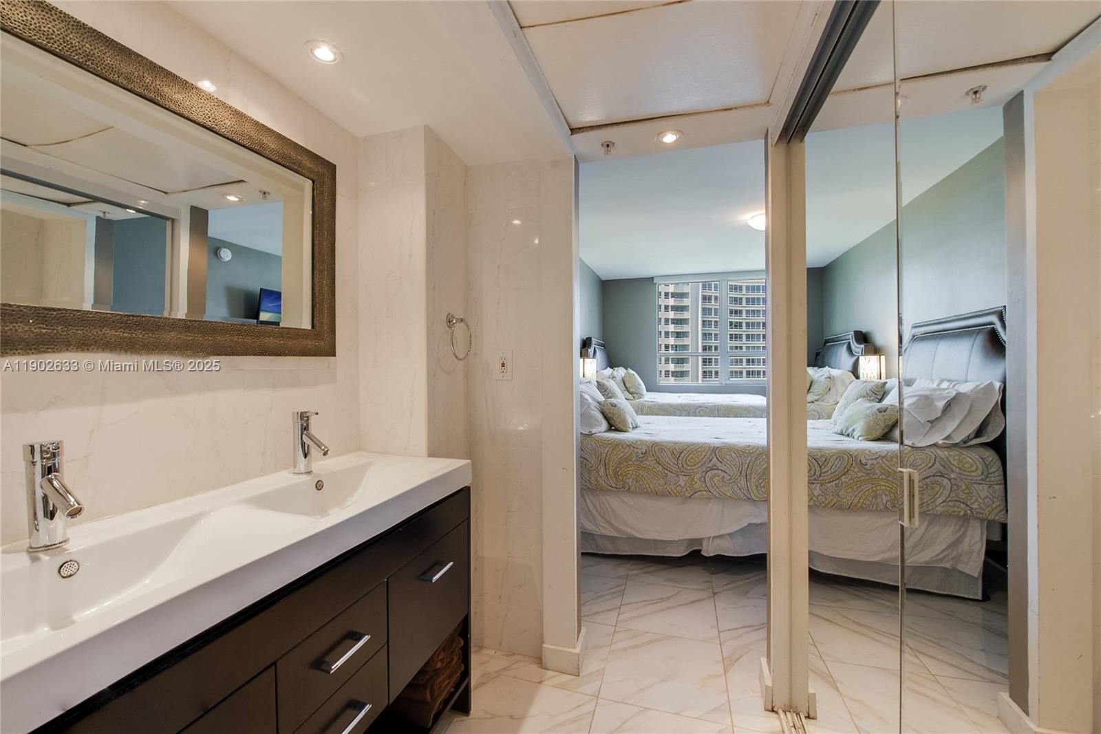 1500 Bay Road, Unit 846S Miami Beach, FL 33139 - Photo 13 of 40 a en suite bathroom with a double vanity sink and mirror
