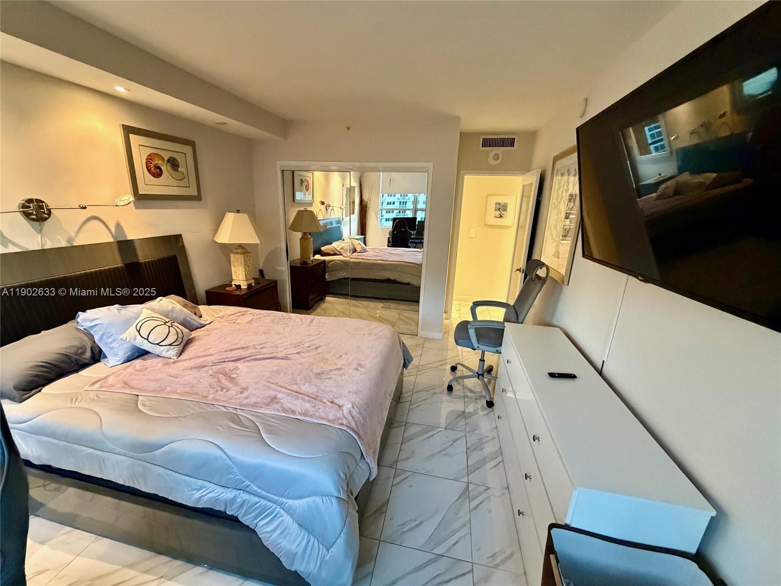 1500 Bay Road, Unit 846S Miami Beach, FL 33139 - Photo 15 of 40 a bedroom with a bed and wooden floor