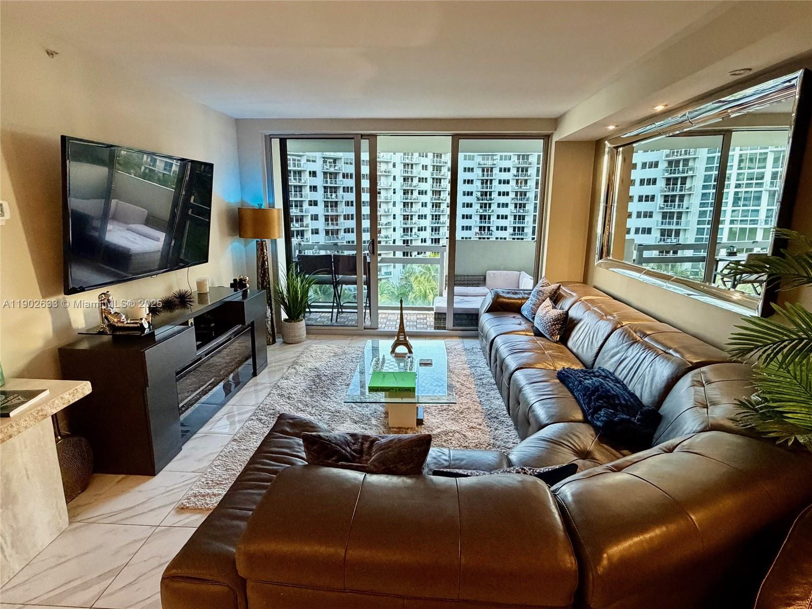 1500 Bay Road, Unit 846S Miami Beach, FL 33139 - Photo 4 of 40 a living room with furniture and a flat screen tv
