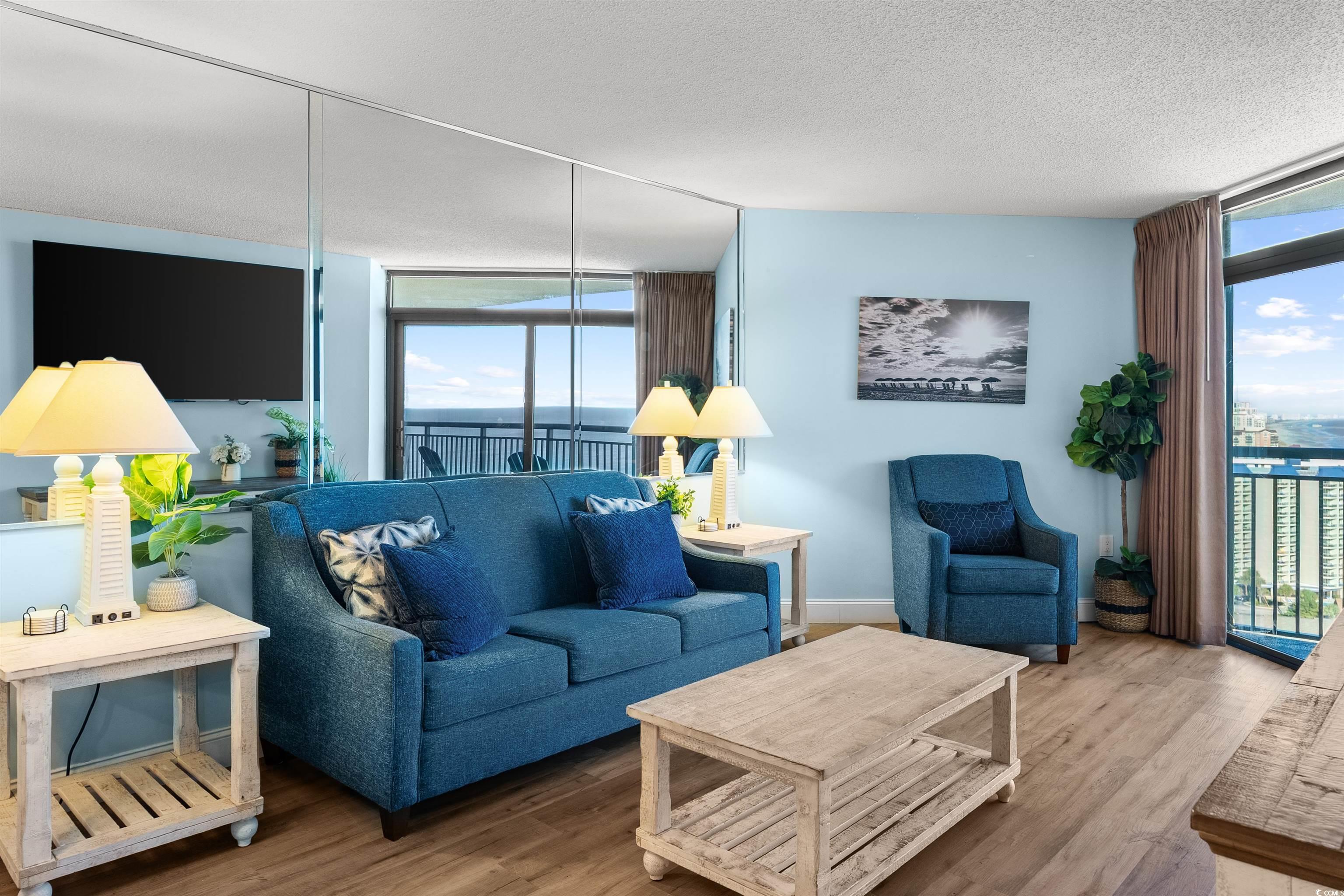 205 74th Avenue North, Unit 1908 Myrtle Beach, SC 29572 - Photo 14 of 39 Living area with floor to ceiling windows, wood finished floors, healthy amount of natural light, and a textured ceiling