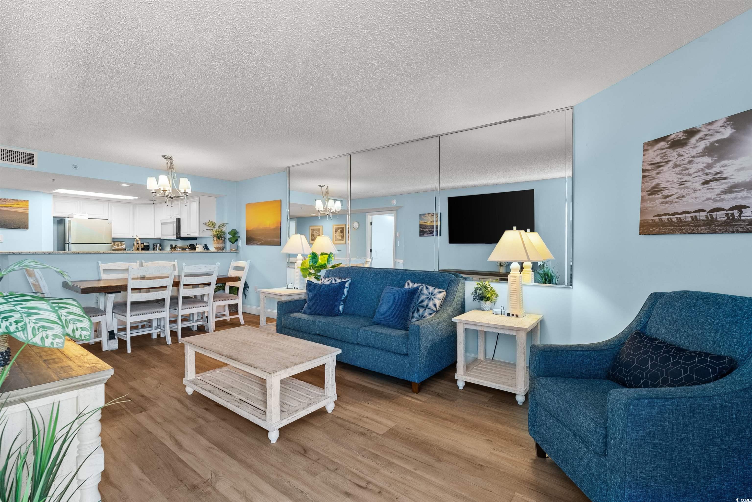205 74th Avenue North, Unit 1908 Myrtle Beach, SC 29572 - Photo 19 of 39 Living room featuring a textured ceiling, a chandelier, and light wood finished floors