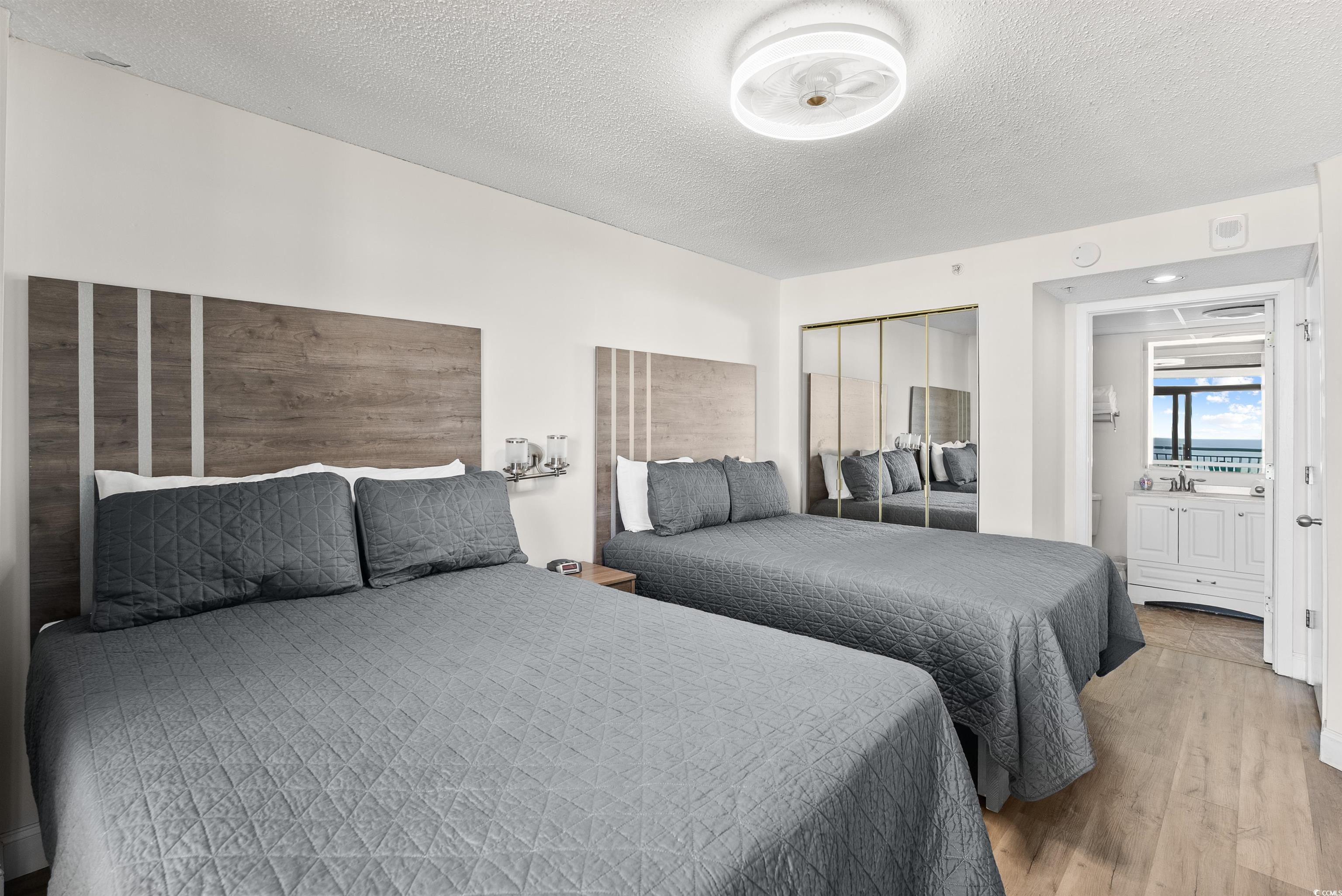 205 74th Avenue North, Unit 1908 Myrtle Beach, SC 29572 - Photo 20 of 39 Bedroom with a textured ceiling, a closet, and wood finished floors