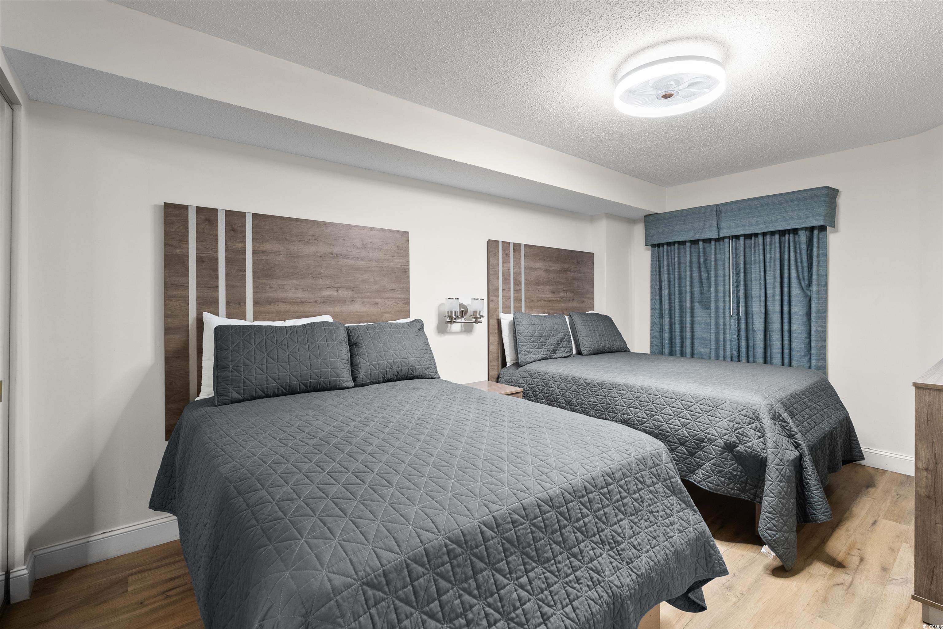 205 74th Avenue North, Unit 1908 Myrtle Beach, SC 29572 - Photo 22 of 39 Bedroom with a textured ceiling and wood finished floors