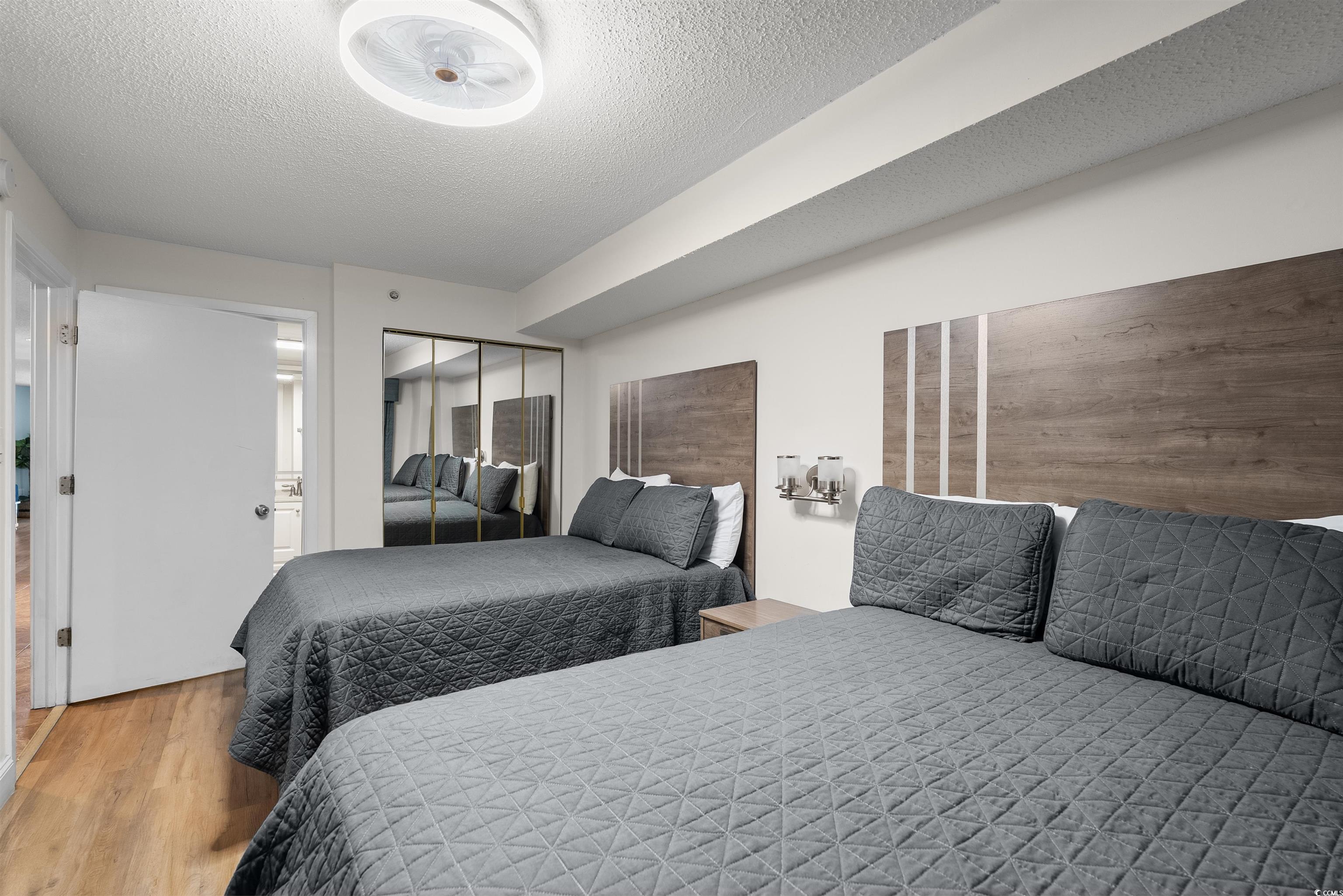 205 74th Avenue North, Unit 1908 Myrtle Beach, SC 29572 - Photo 24 of 39 Bedroom featuring a textured ceiling, wood finished floors, and a closet