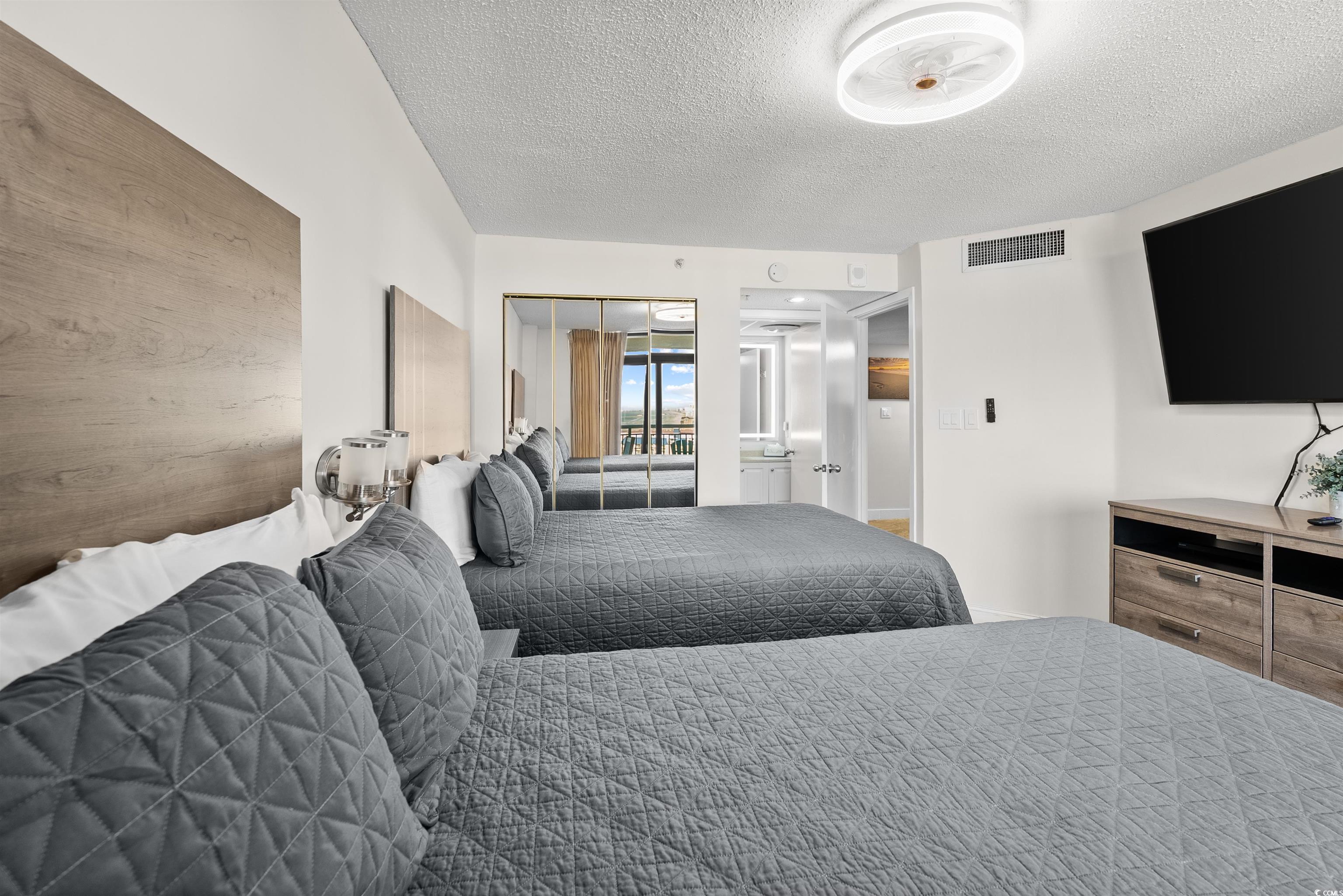 205 74th Avenue North, Unit 1908 Myrtle Beach, SC 29572 - Photo 28 of 39 Bedroom featuring a textured ceiling and a closet