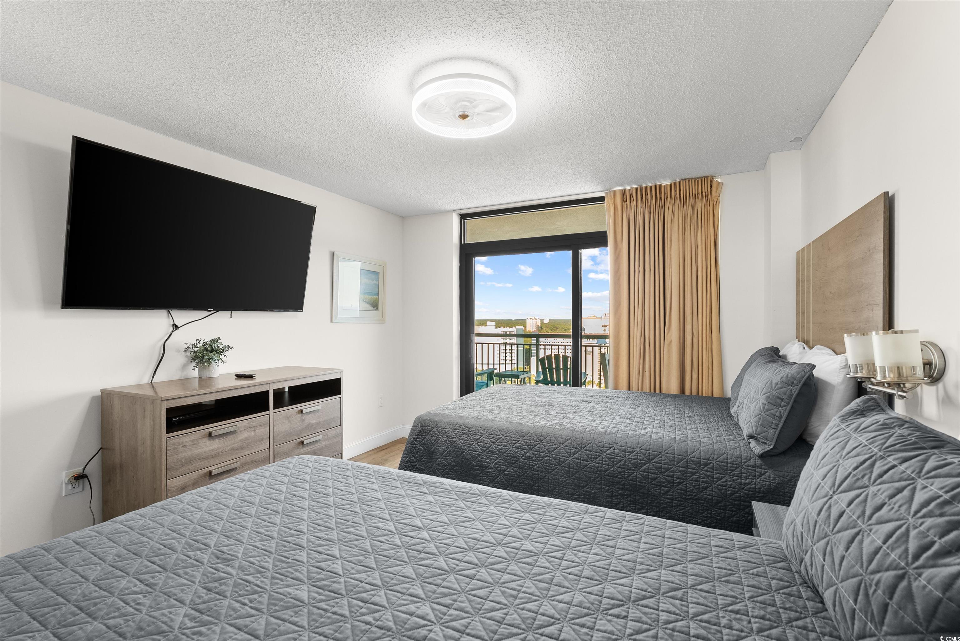 205 74th Avenue North, Unit 1908 Myrtle Beach, SC 29572 - Photo 29 of 39 Bedroom featuring a textured ceiling, access to exterior, and expansive windows