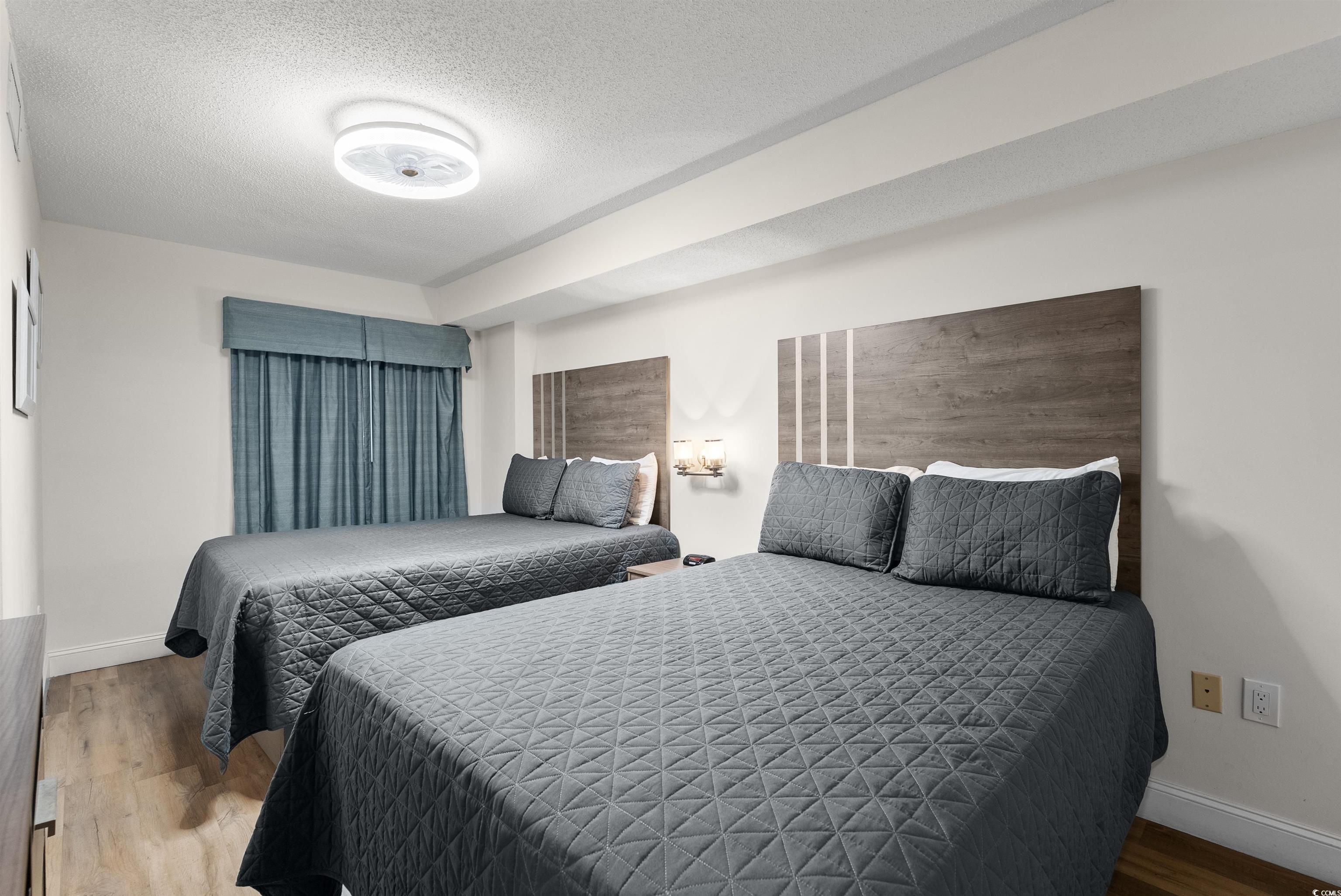 205 74th Avenue North, Unit 1908 Myrtle Beach, SC 29572 - Photo 30 of 39 Bedroom featuring a textured ceiling and wood finished floors