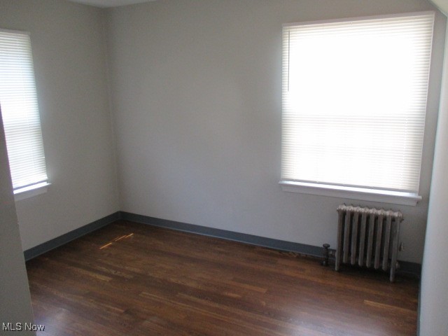3703 Bainbridge Road Cleveland Heights, OH 44118 - Photo 6 of 16 Empty room with dark wood-style flooring and radiator