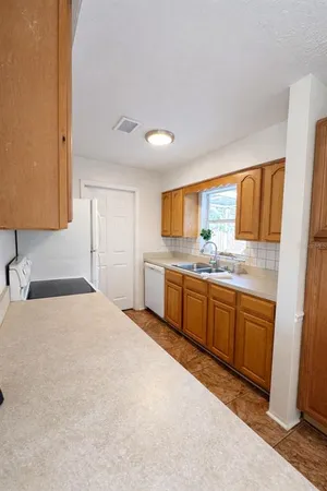a large white kitchen with sink and white cabinets