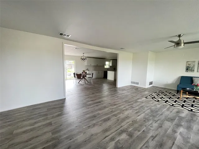 a view of a livingroom with wooden floor and a ceiling fan