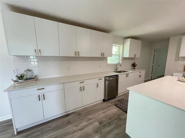 a kitchen with cabinets appliances a sink and a window