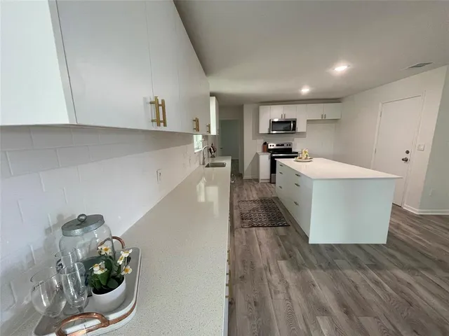 a view of a kitchen with furniture and wooden floor