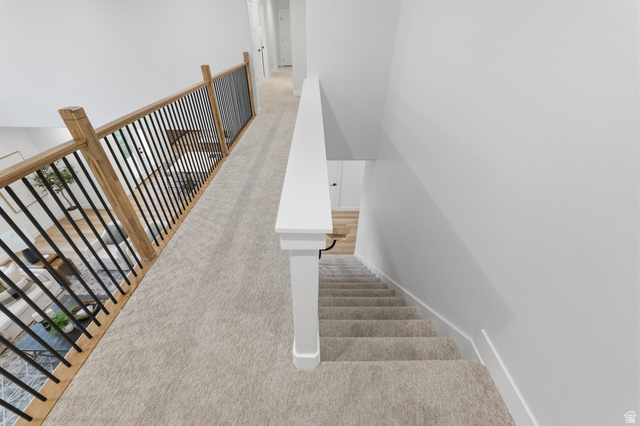 702 Alpine Highway Alpine, UT 84004 - Photo 39 of 83 Upper-level hallway featuring light-toned carpeting, a white handrail, and a contemporary wood and black metal baluster system overlooking the lower level