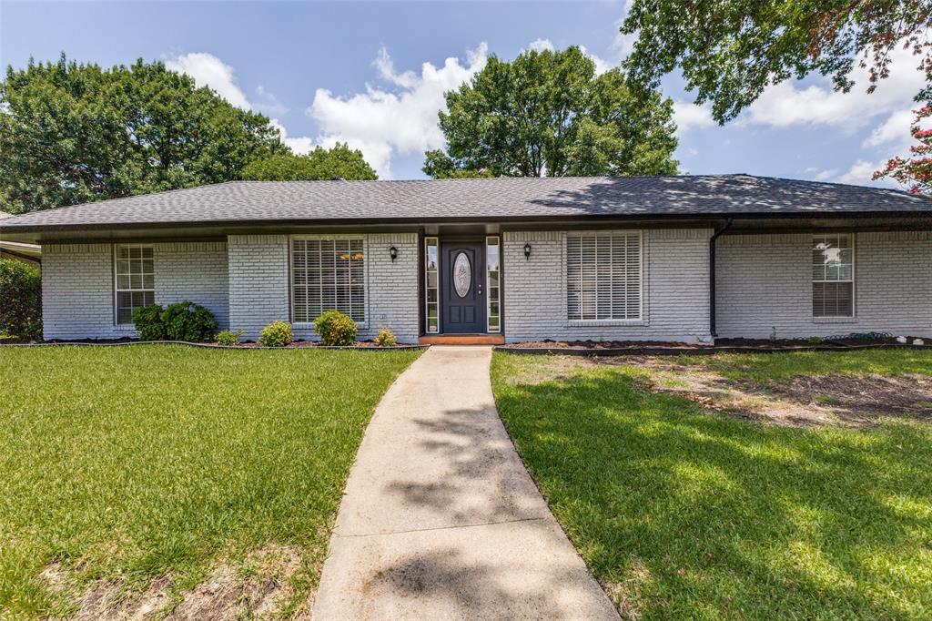 a front view of a house with a garden and yard