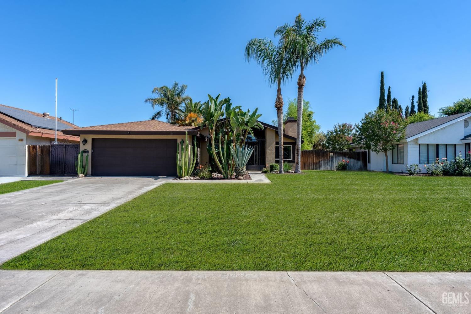 a front view of a house with a yard and a garage