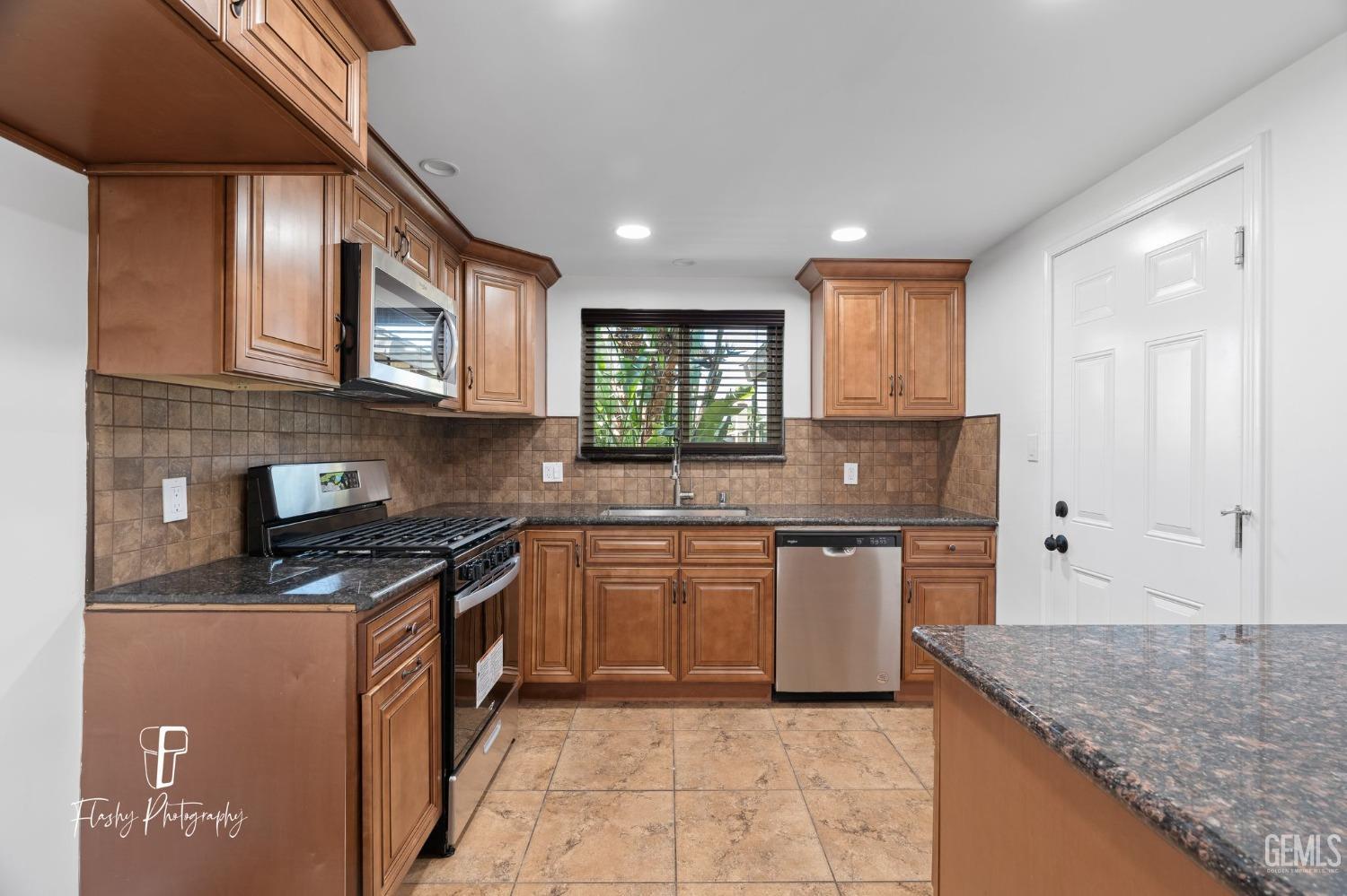 Undisclosed Address Bakersfield, CA 93309 - Photo 12 of 32 a kitchen with stainless steel appliances granite countertop a sink stove and cabinets
