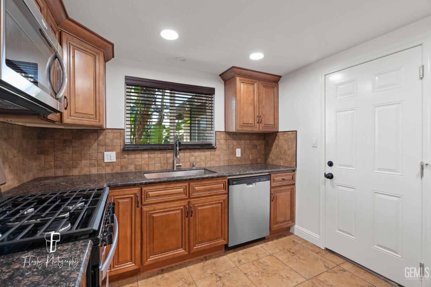 Undisclosed Address Bakersfield, CA 93309 - Photo 13 of 32 a kitchen with granite countertop a sink stove and cabinets