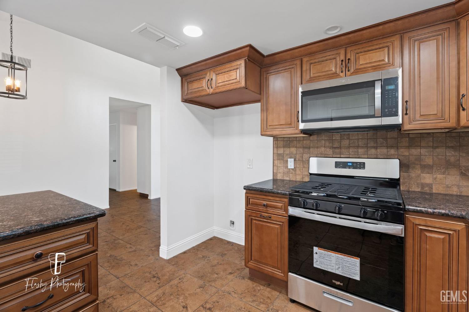 Undisclosed Address Bakersfield, CA 93309 - Photo 14 of 32 a kitchen with stainless steel appliances granite countertop a stove and a microwave