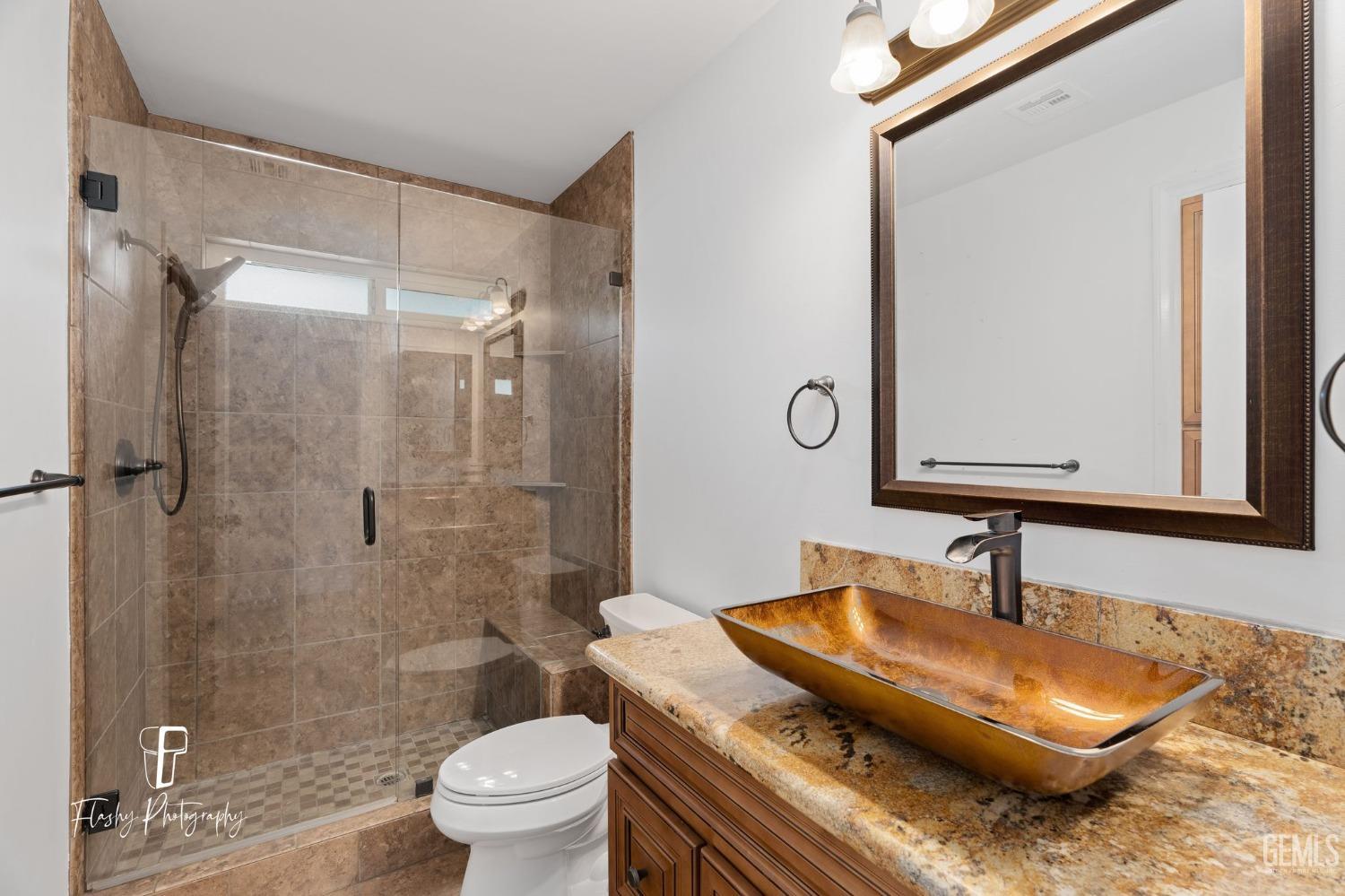 Undisclosed Address Bakersfield, CA 93309 - Photo 19 of 32 a bathroom with a sink a toilet and a mirror