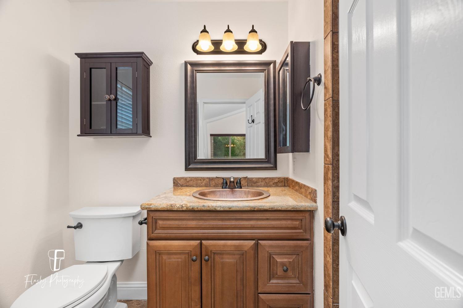 Undisclosed Address Bakersfield, CA 93309 - Photo 23 of 32 a bathroom with a sink vanity mirror and toilet