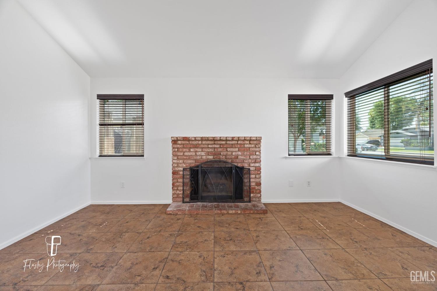 Undisclosed Address Bakersfield, CA 93309 - Photo 8 of 32 an empty room with windows and fireplace