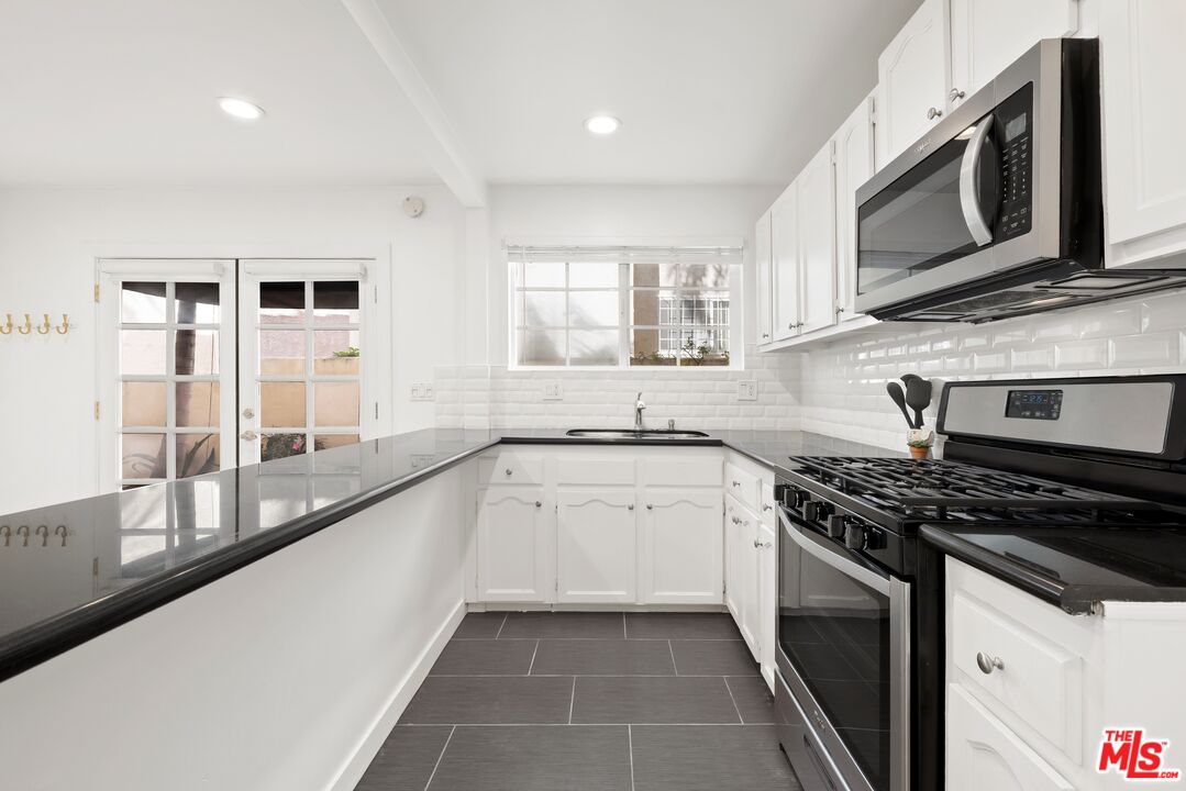 927 Euclid Street, Unit B Santa Monica, CA 90403 - Photo 4 of 8 a kitchen with stainless steel appliances a stove sink microwave and cabinets