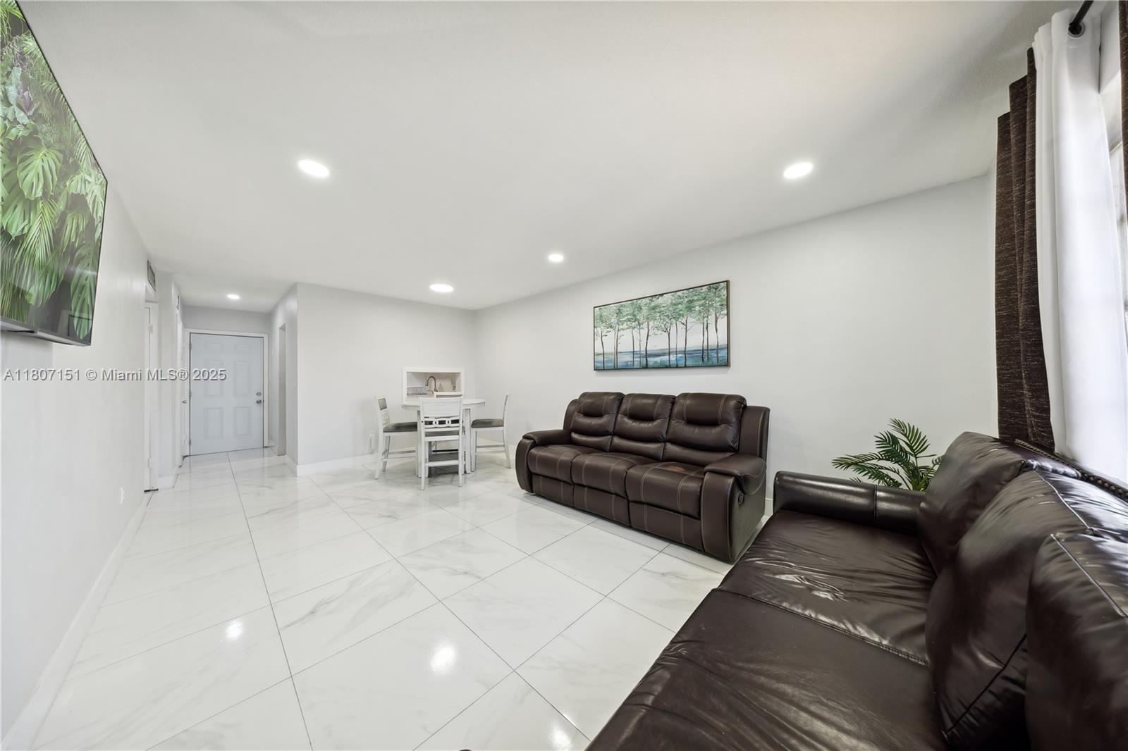 140 Royal Palm Road, Unit 3144 Hialeah Gardens, FL 33016 - Photo 17 of 23 a living room with furniture and a flat screen tv