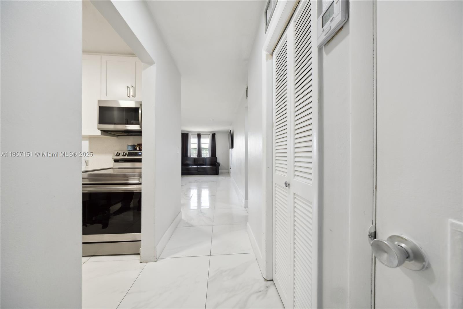 140 Royal Palm Road, Unit 3144 Hialeah Gardens, FL 33016 - Photo 8 of 23 a hallway with a sink and cabinets
