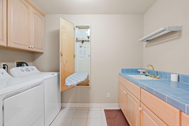a utility room with cabinets washer and dryer