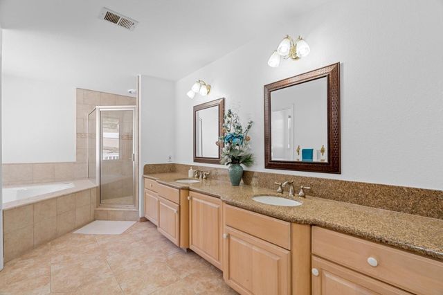 a bathroom with a granite countertop sink a large mirror and a bathtub