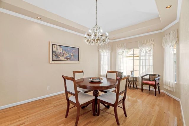 a dining room with furniture a chandelier and wooden floor