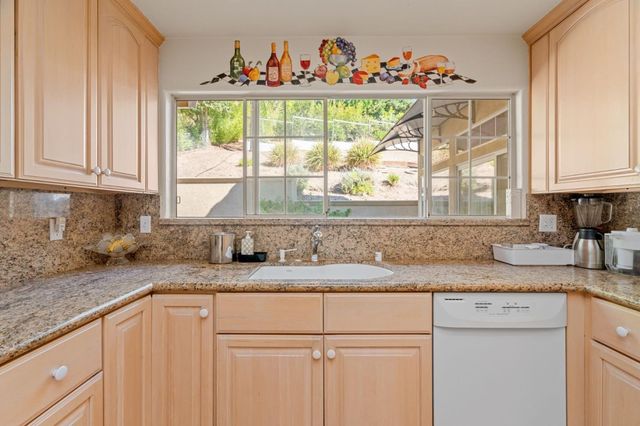 a kitchen with granite countertop white cabinets and a window