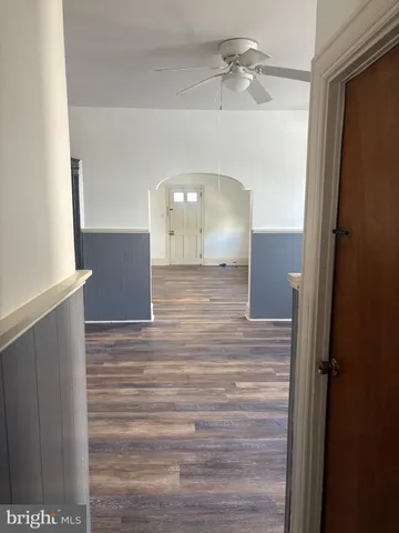 a view of a hallway with a chandelier fan