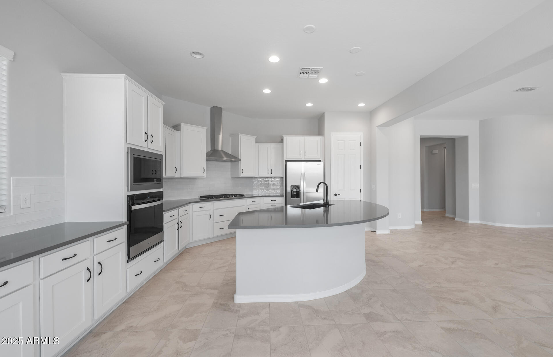 7906 West Mockingbird Way Florence, AZ 85132 - Photo 12 of 36 a large white kitchen with stainless steel appliances granite countertop a sink a stove and a refrigerator