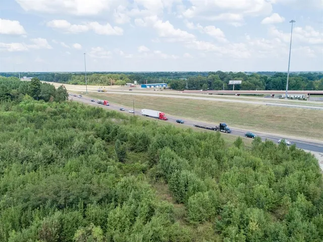 a view of a lake with a big yard and large trees