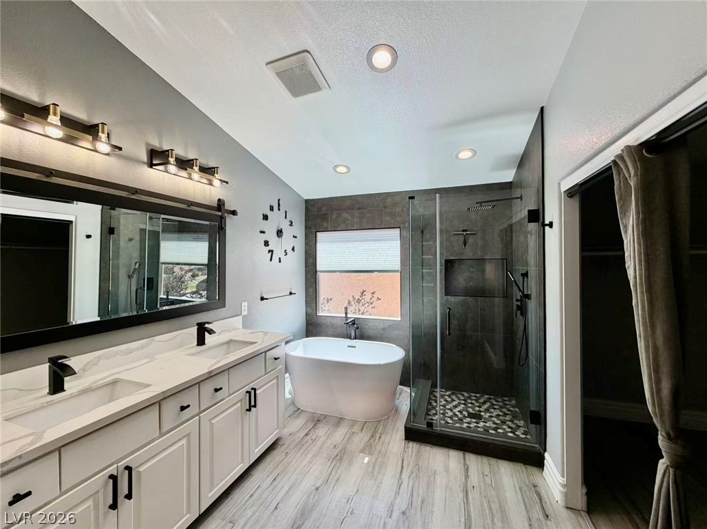 135 Tall Ruff Drive Las Vegas, NV 89148 - Photo 17 of 29 Indulge in a spa-like retreat with this serene bathroom, featuring a freestanding tub and spacious walk-in shower.
